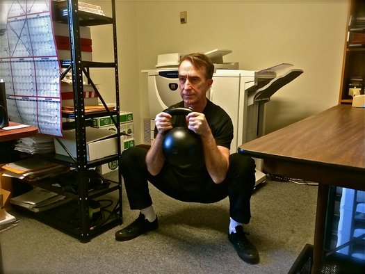 Office Workout John Du Cane performs a 30kg Goblet Squat at the Dragon Door Office